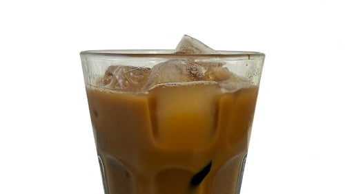 Glass of iced coffee with ice cubes on a white background